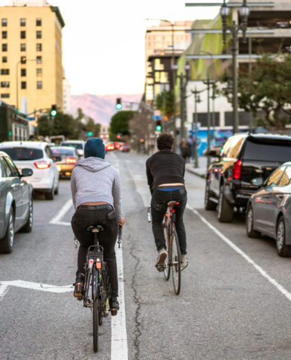https://www.citythread.org/wp-content/uploads/2022/05/Cyclists-passing-LA-traffic-stock-photo_istock-420x520.jpg
