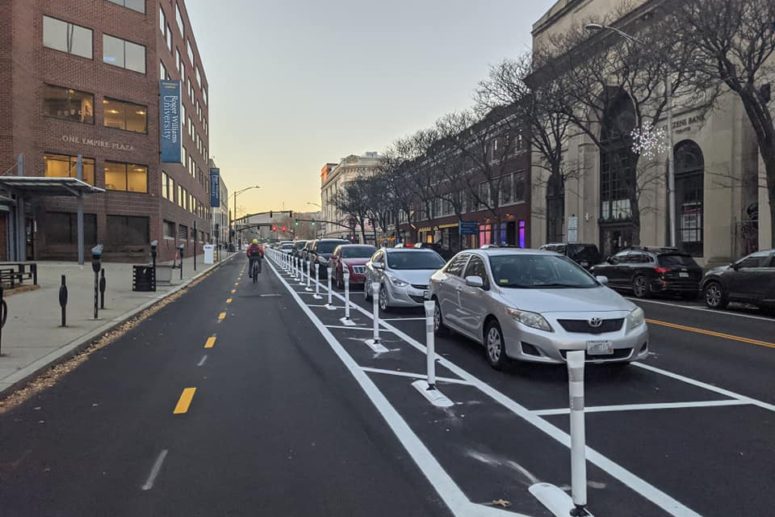 A person on a bike is riding on a two-way protected bike lane.